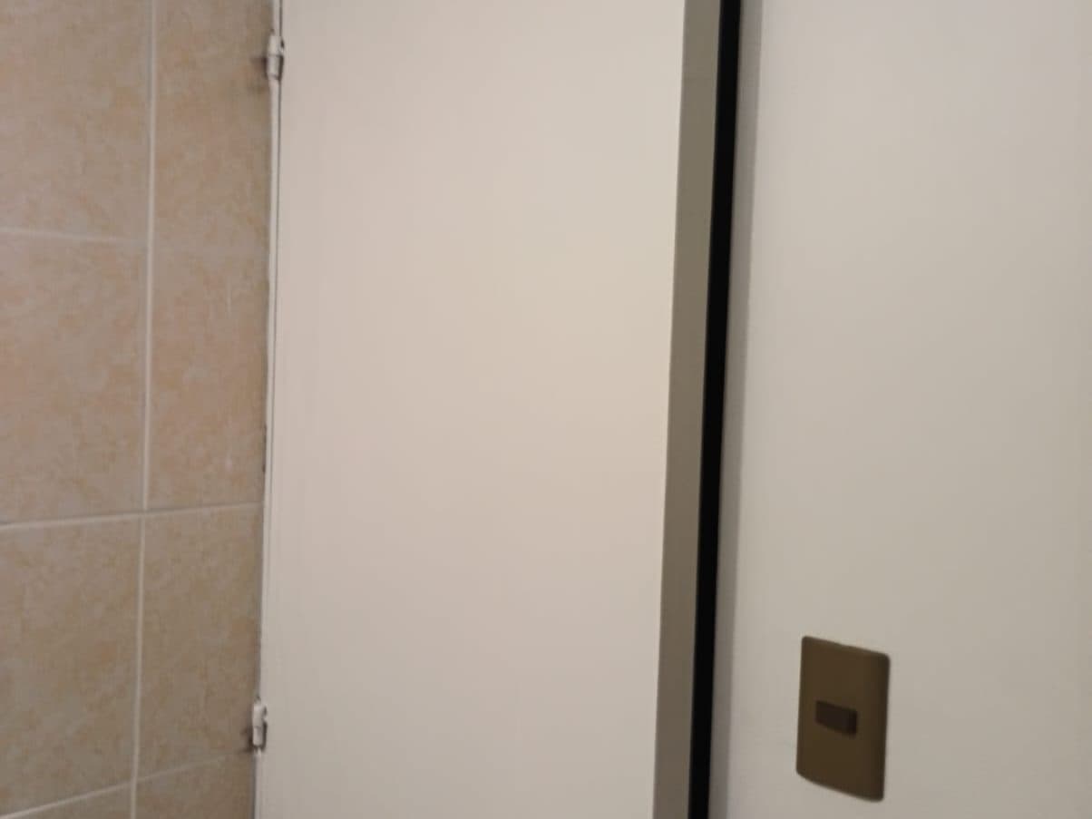 Puerta y muro recién pintados en blanco