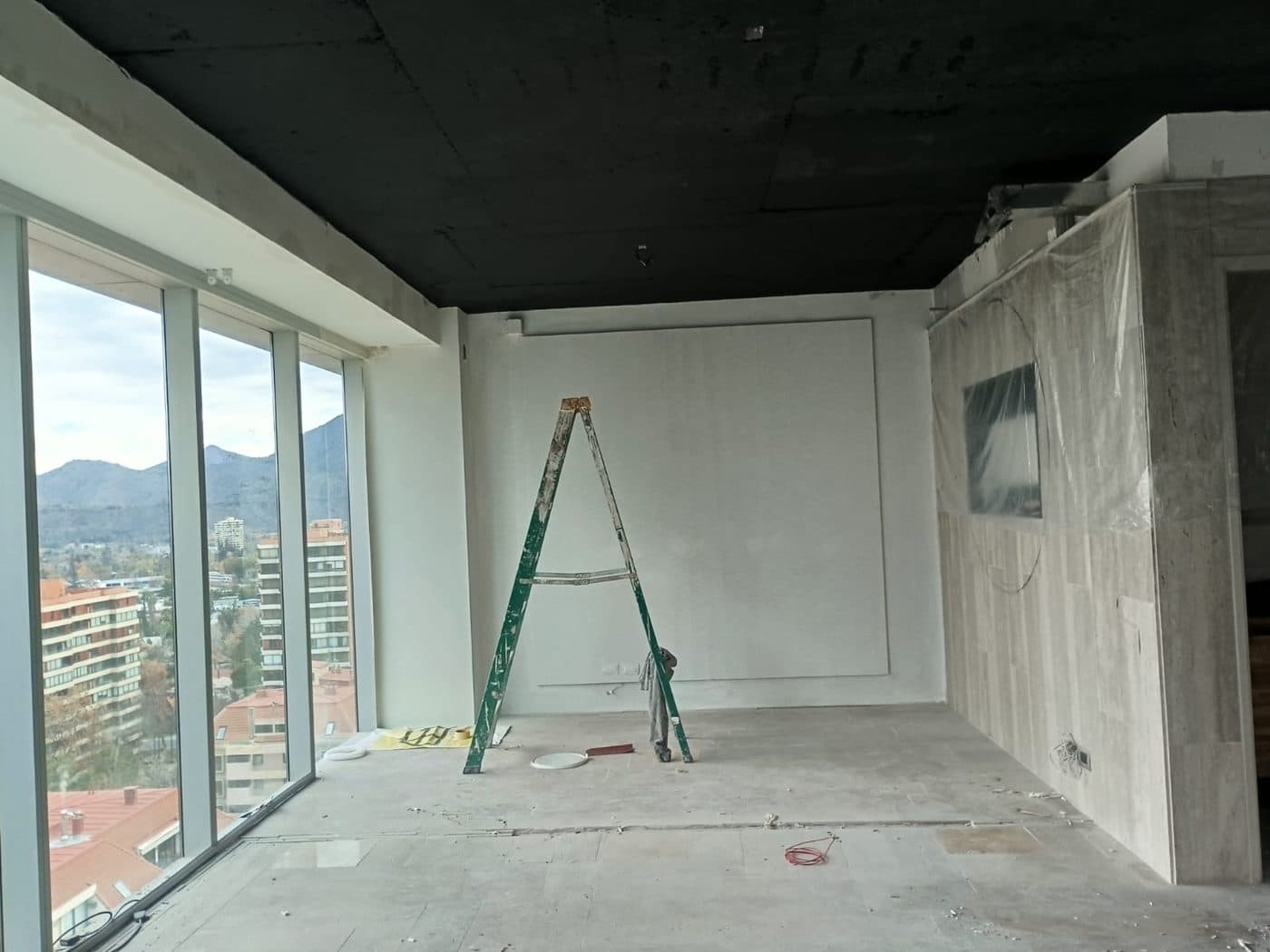 Sala vacía recién pintada, con la escalera todavía adentro