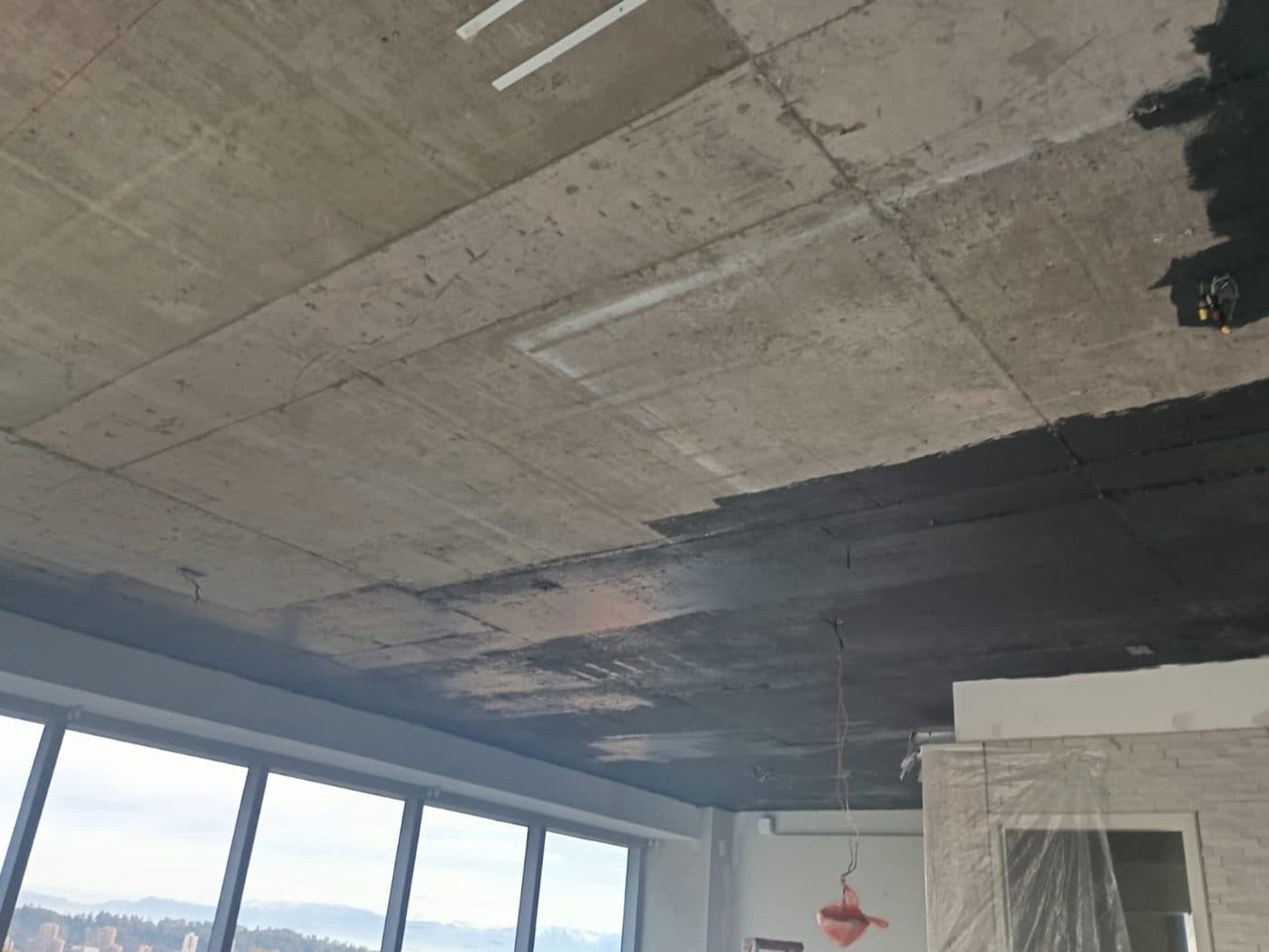 Cielo de losa a medio pintar, con los ventanales protegidos